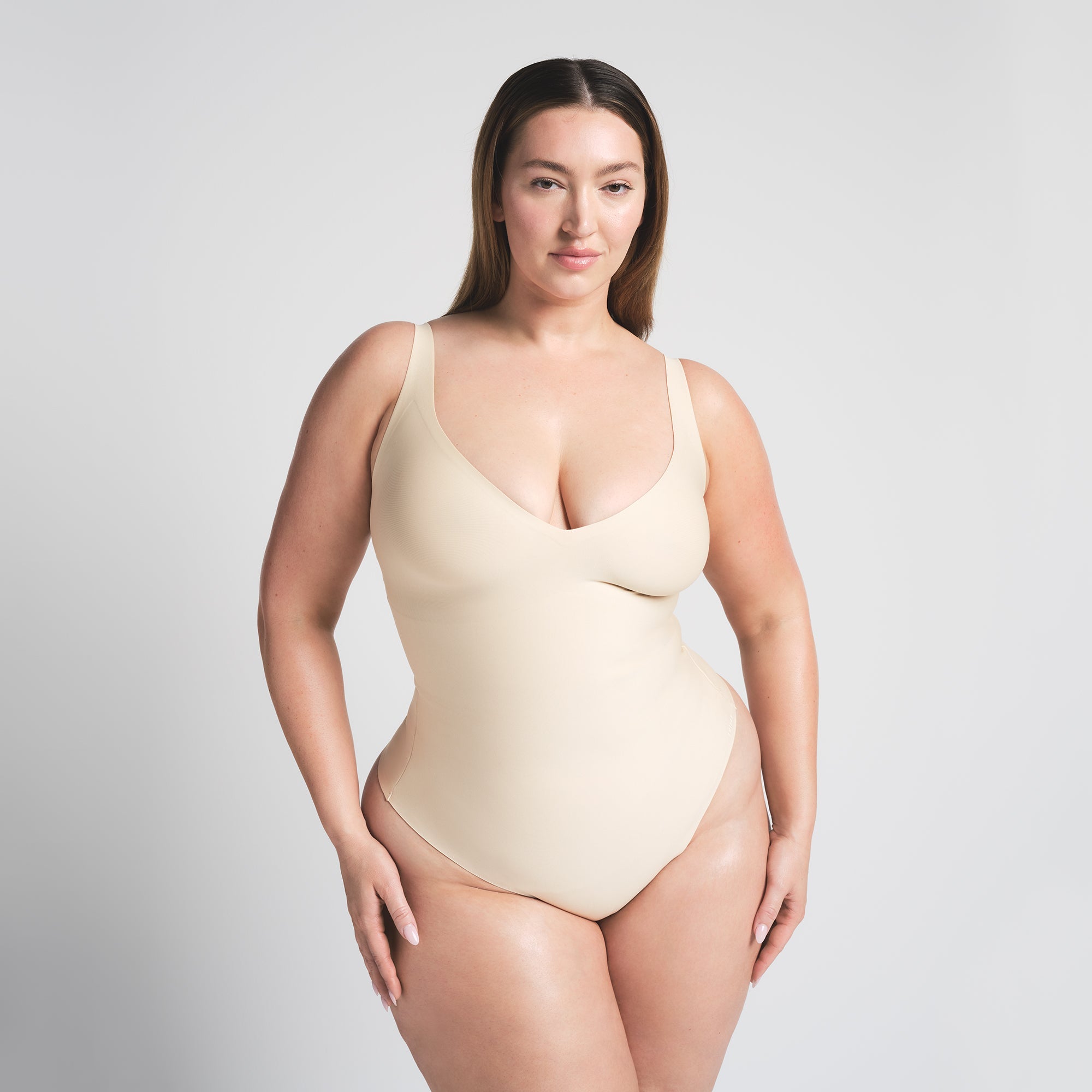 SKIMS BODY UNLINED PLUNGE THONG BODYSUIT | SAND